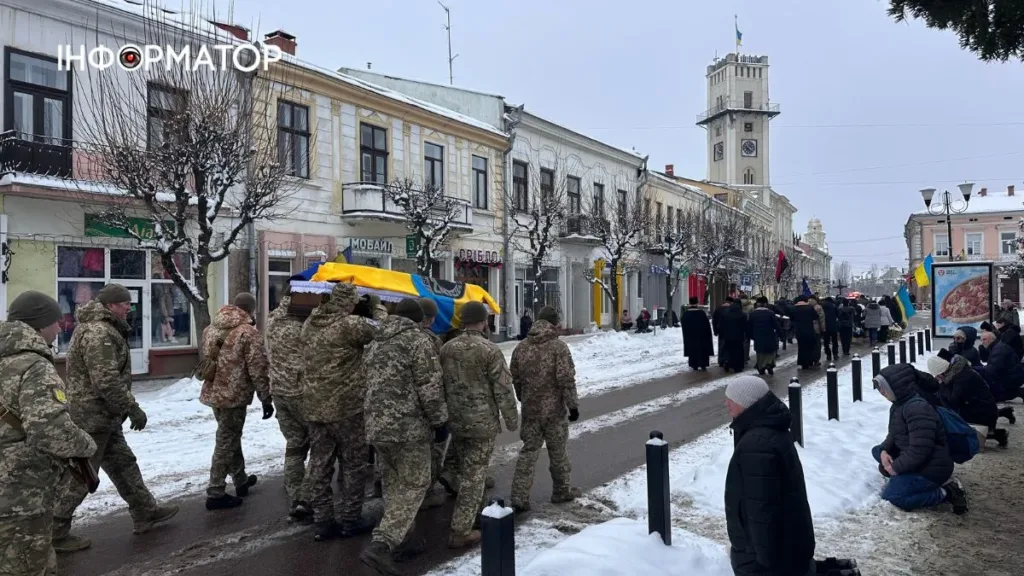 Військові несуть труну з прапором України взимку