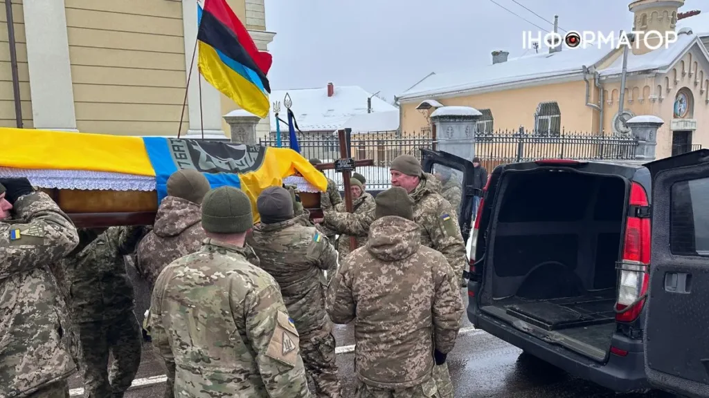 Військові несуть труну з українським прапором