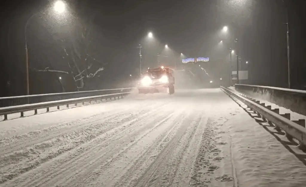 Снігоприбиральна машина чистить засніжену дорогу вночі