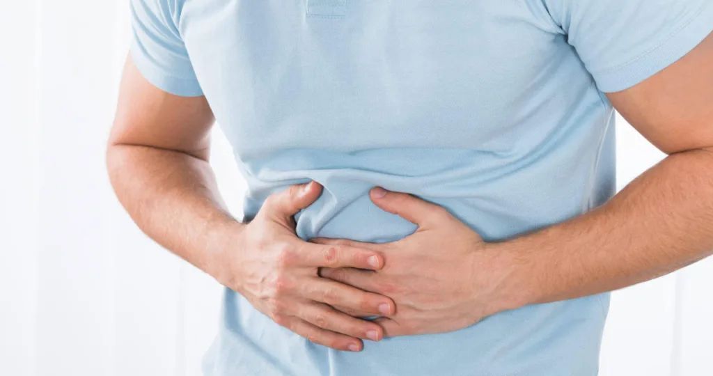 Чоловік тримається за живіт через біль
