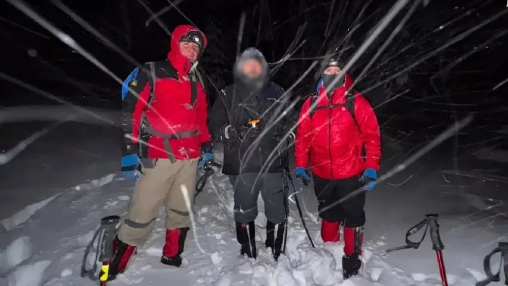Туристи у сніговій бурі вночі у горах