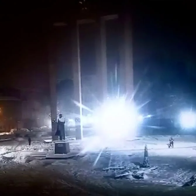 Нічна площа зі снігом і яскравими вогнями