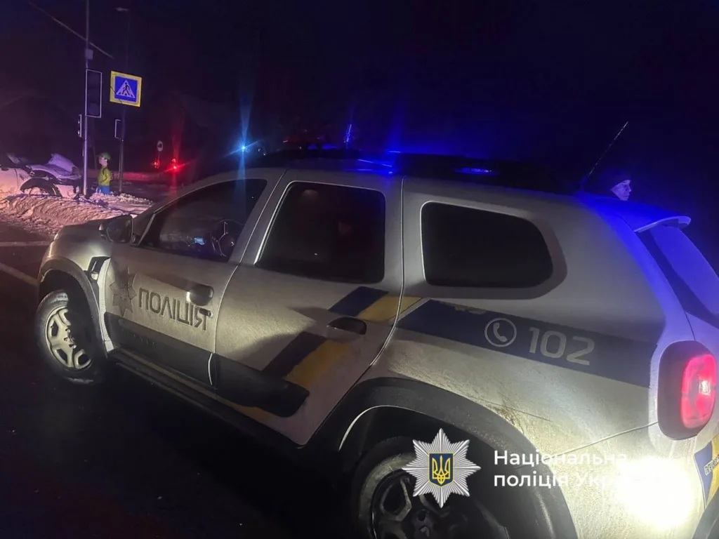 Поліцейський автомобіль на місці ДТП уночі