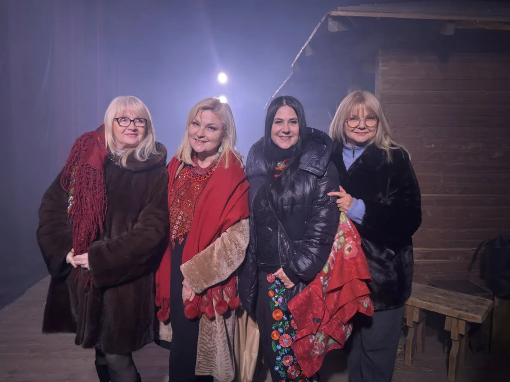 Чотири жінки в теплих пальтах позують разом