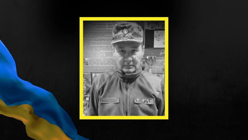 Український військовий у формі на фоні стенду