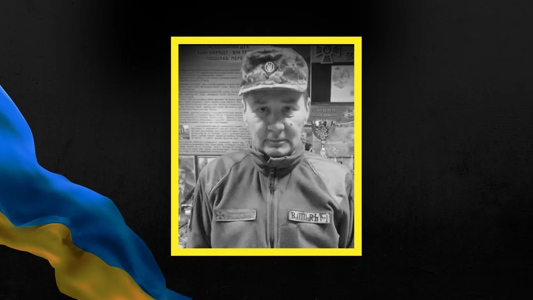 Український військовий у формі на фоні стенду