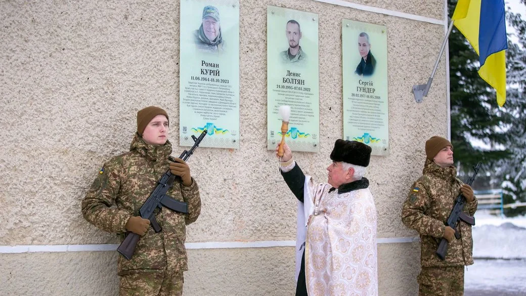 Священник освячує меморіальну дошку українським захисникам