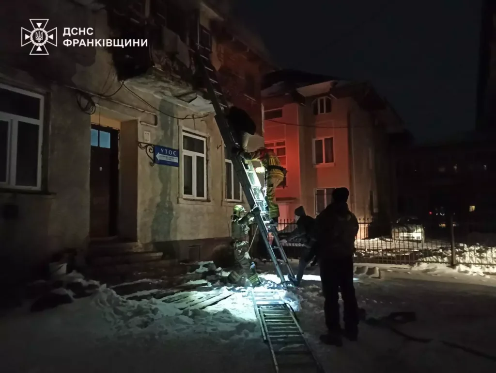 Рятувальники працюють біля будинку вночі