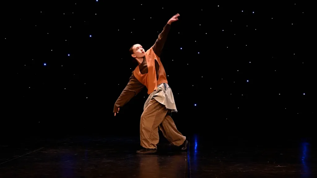 Танцівник виступає на сцені під зоряним світлом