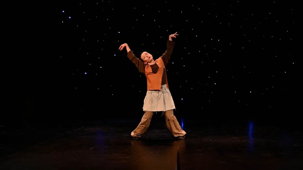 Танцівник виступає на сцені під зірковим фоном