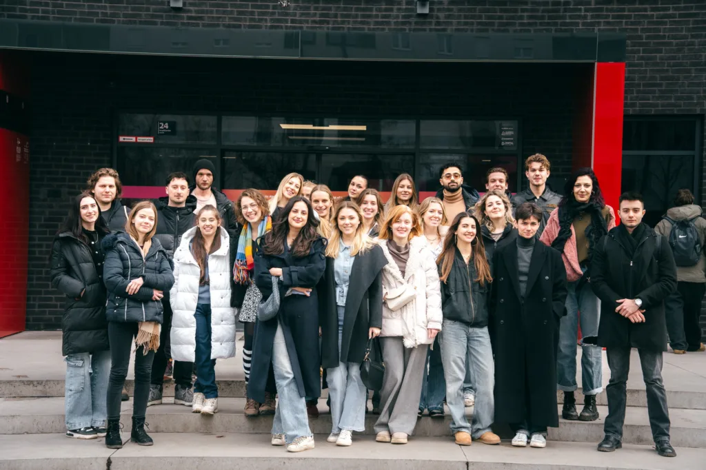 Група студентів перед сучасною будівлею університету