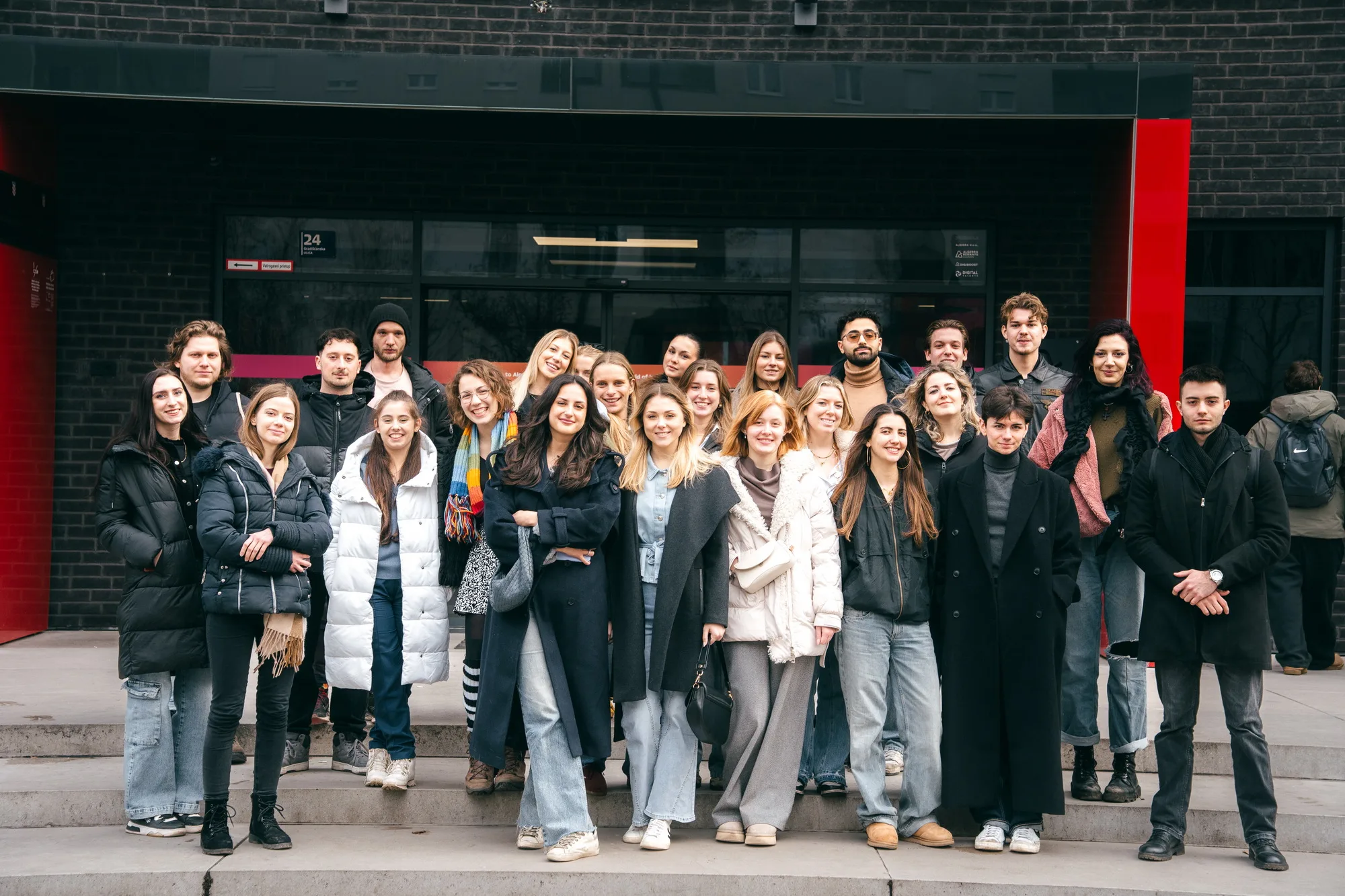 Група студентів перед сучасною будівлею університету