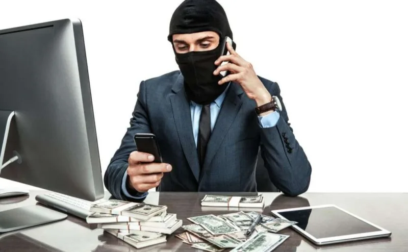 Шахрай у масці з грошима та телефонами