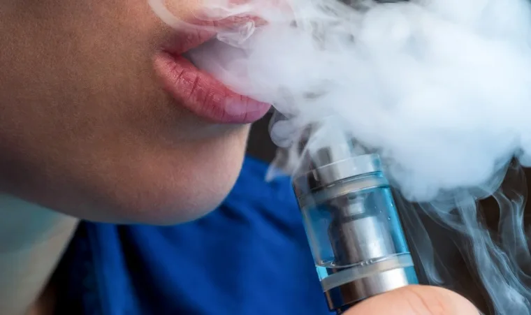Людина випускає пару з електронної сигарети