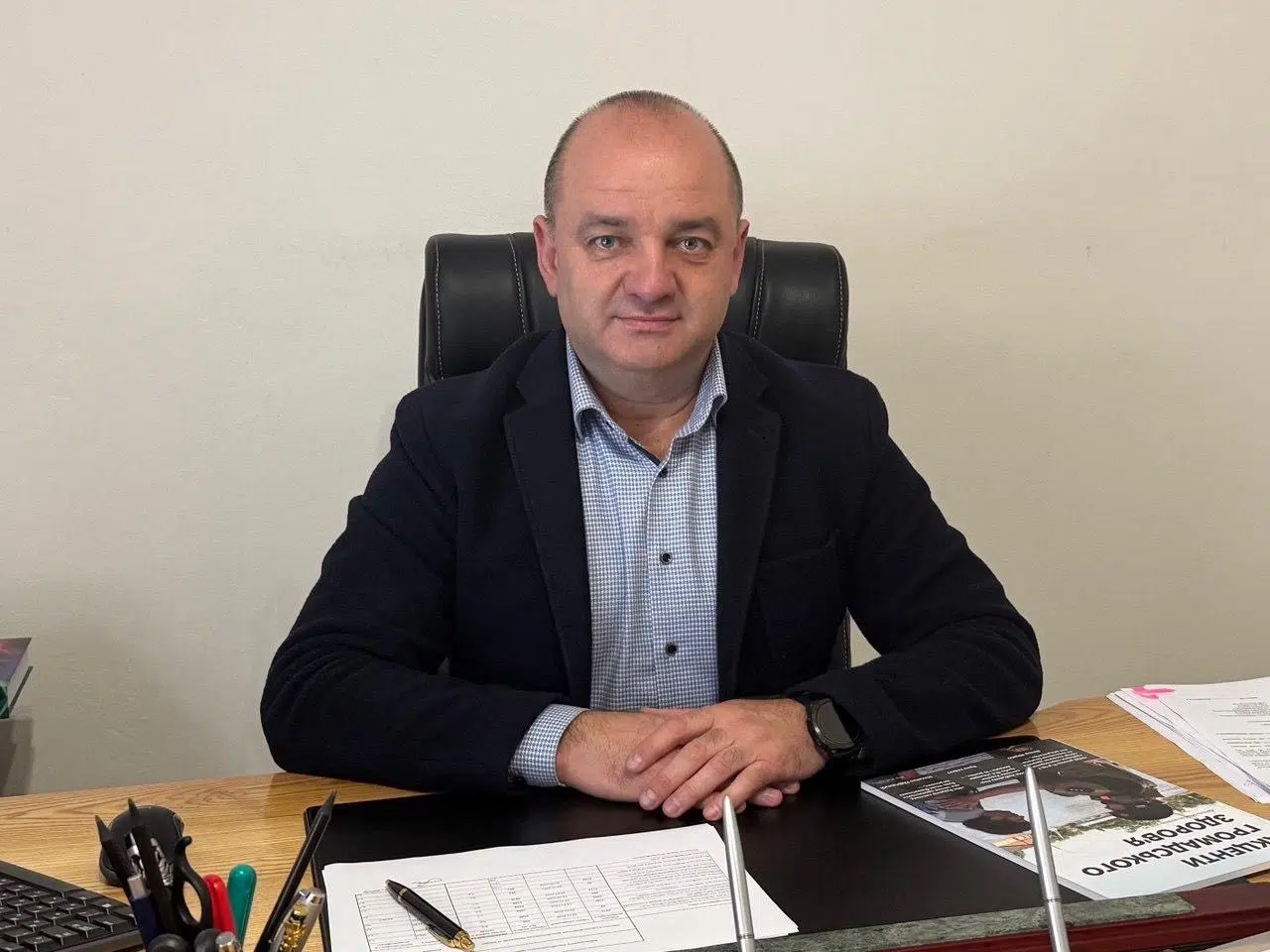 Чоловік сидить за офісним столом у костюмі