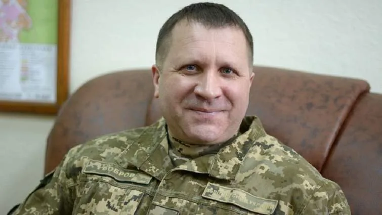 Український військовий у камуфляжній формі усміхається