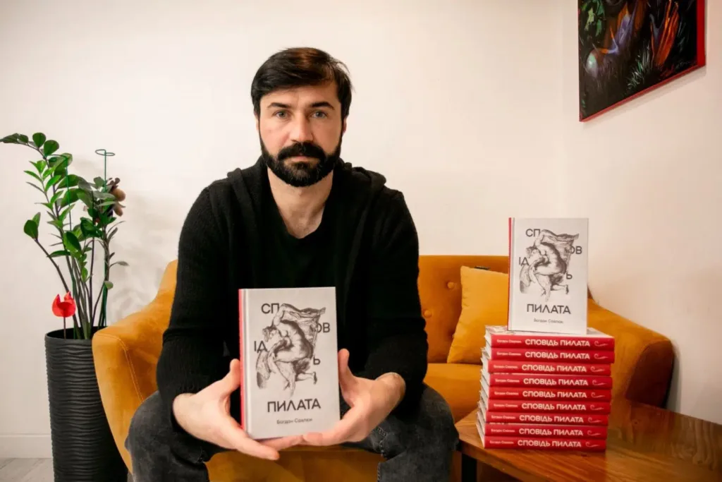 Чоловік тримає книжку Сповідь Пилата