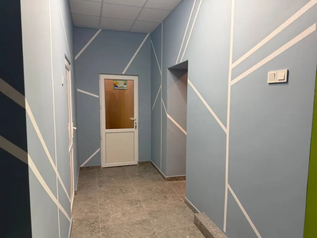 Світлий коридор з синіми стінами та дверима