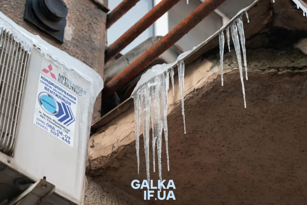 Бурульки звисають з даху біля кондиціонера