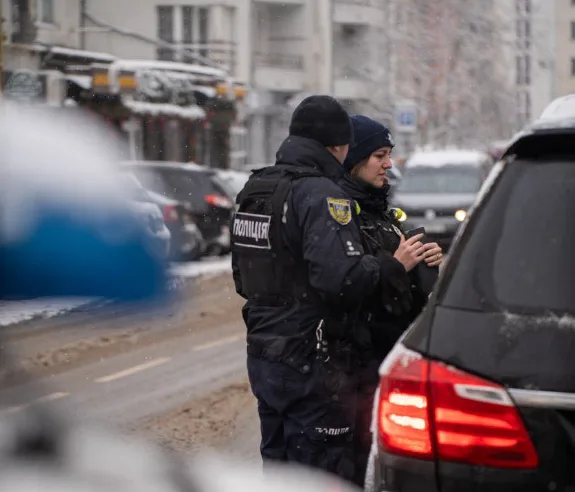 Поліцейські перевіряють автомобіль на зимовій вулиці