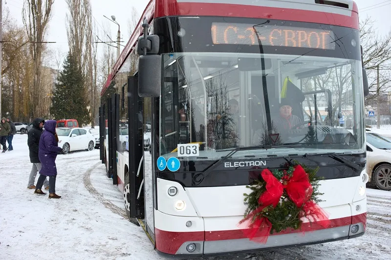 Прикрашений тролейбус взимку на зупинці