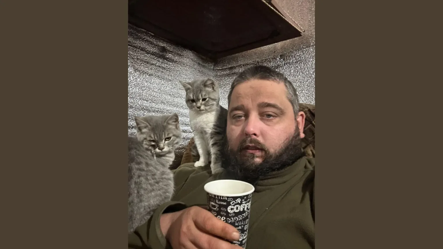 Чоловік з двома сірими котами та чашкою кави