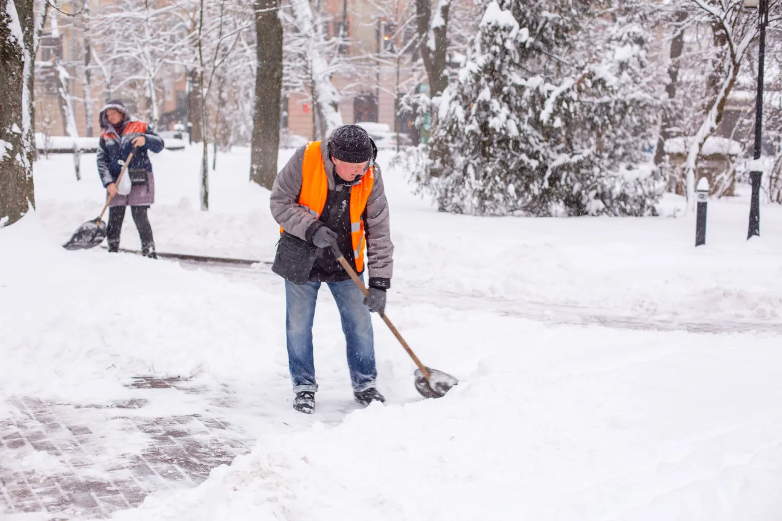 Працівники розчищають сніг на міській вулиці