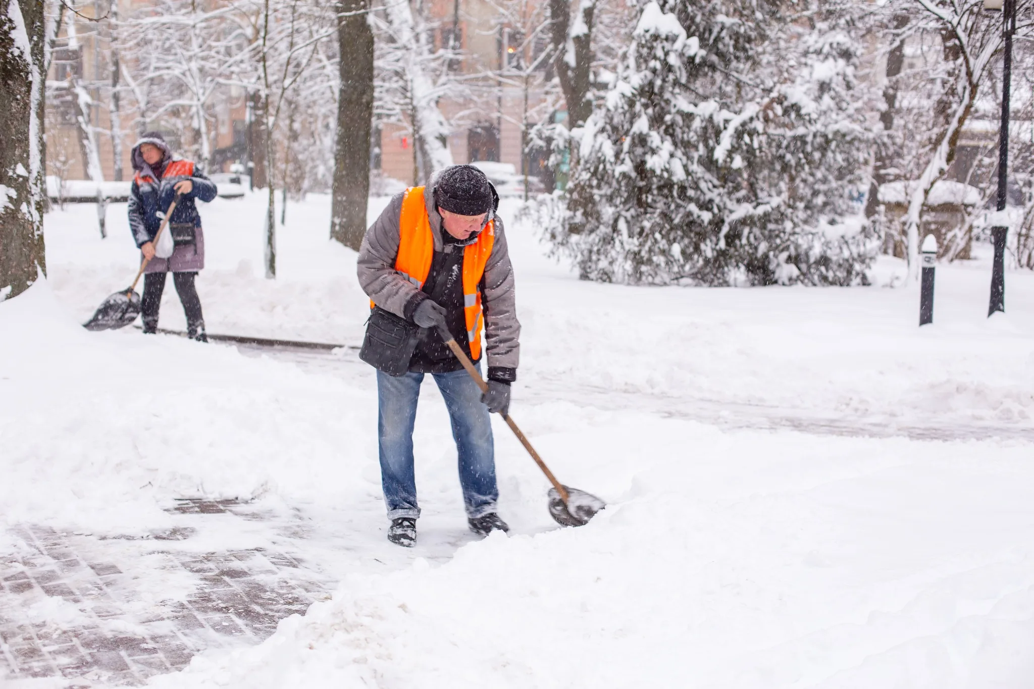 Працівники розчищають сніг на міській вулиці