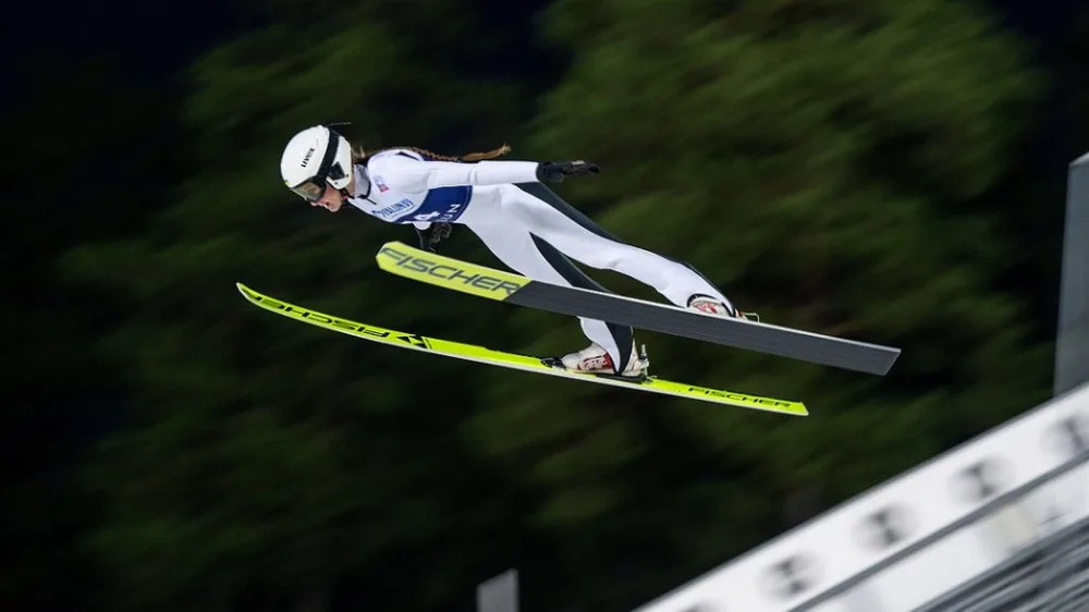 Спортсменка стрибає на лижах із трампліна