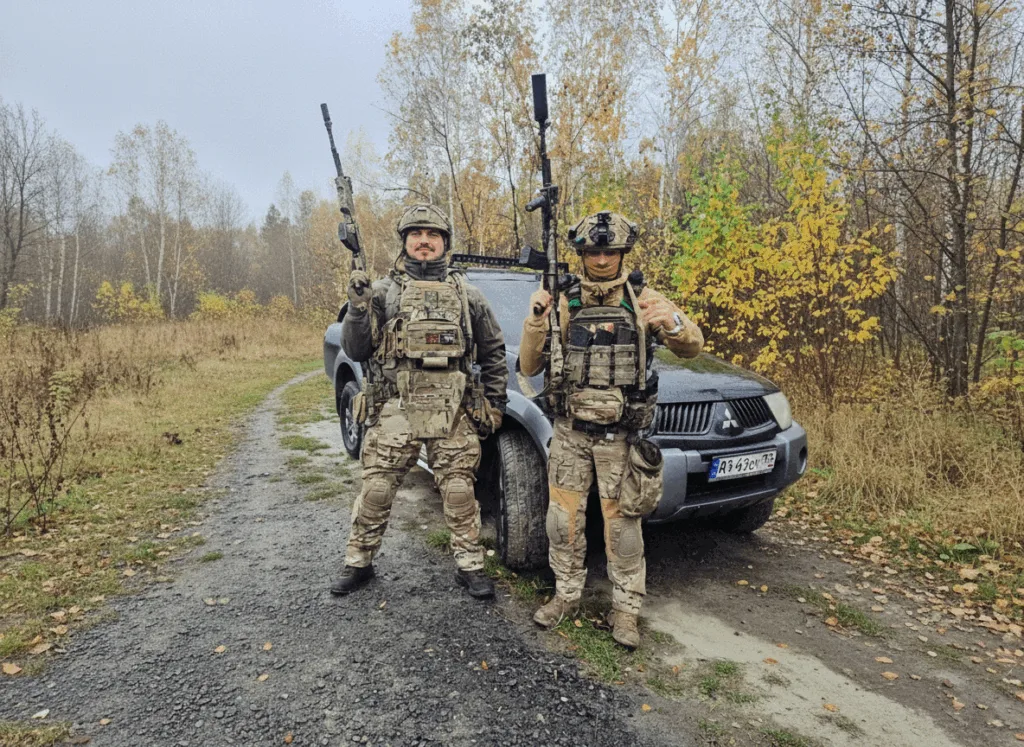 Військові у спорядженні стоять біля автомобіля в лісі