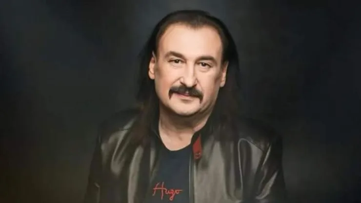 Чоловік у чорній шкіряній куртці на темному тлі