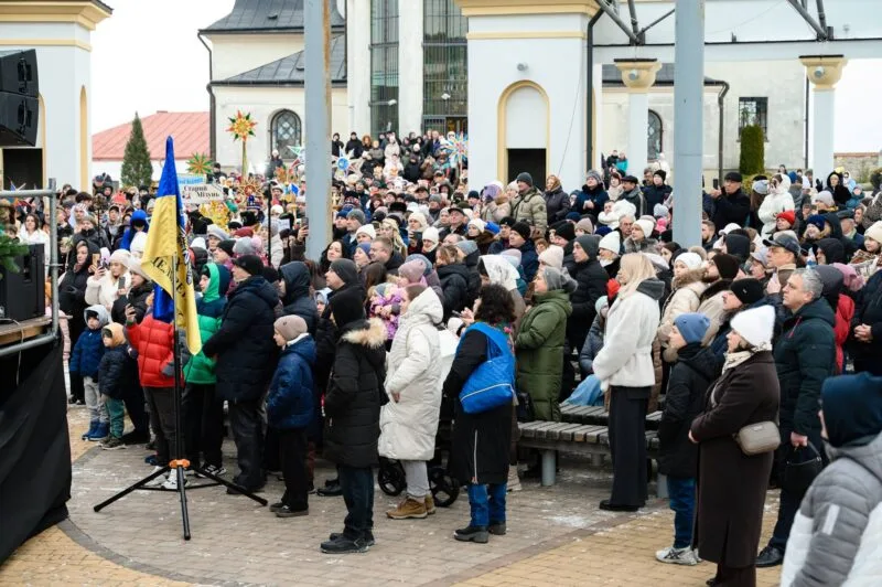 Натовп людей на святковому заході біля церкви