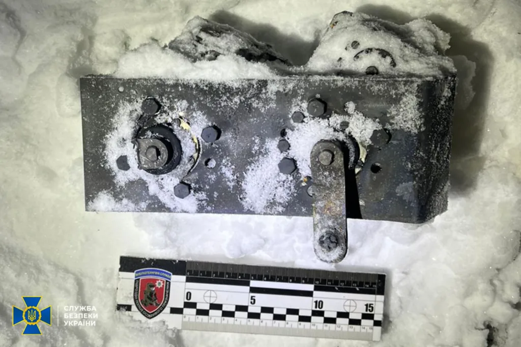 Металевий пристрій у снігу з вимірювальною лінійкою