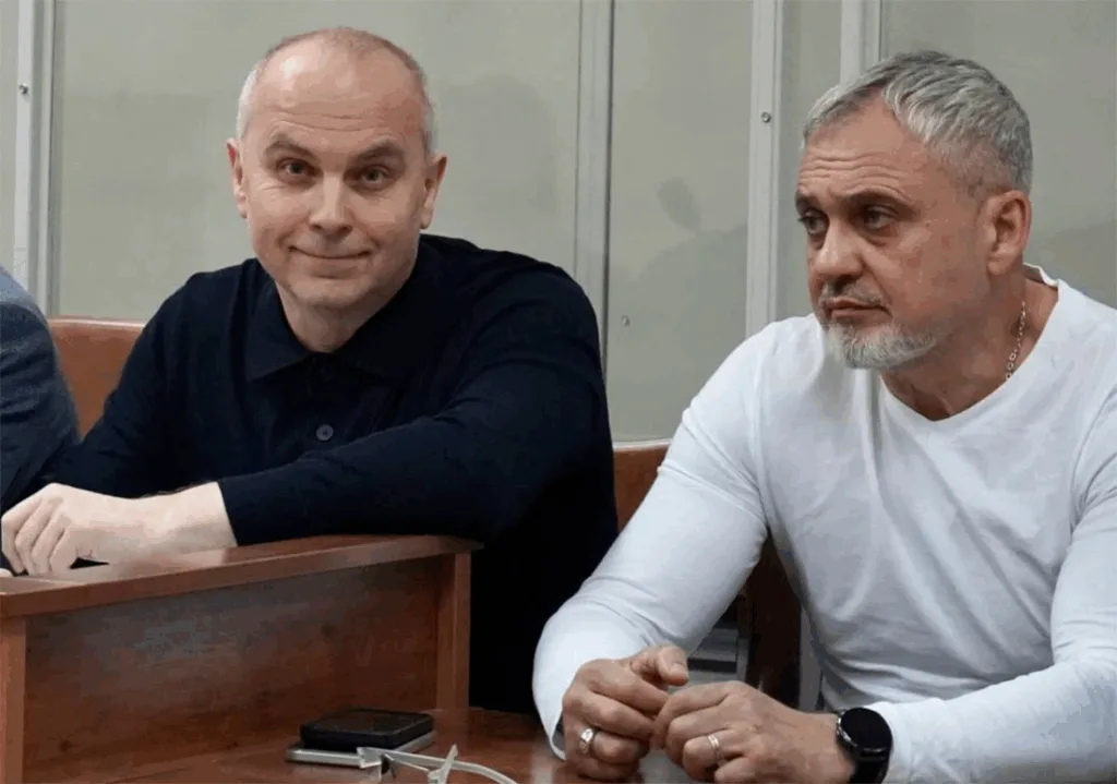 Двоє чоловіків сидять за столом у приміщенні