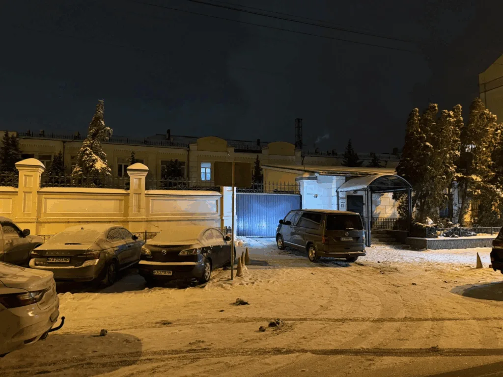 Засніжена паркова зона біля будівлі вночі
