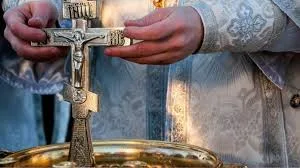 Священник тримає хрест під час обряду освячення