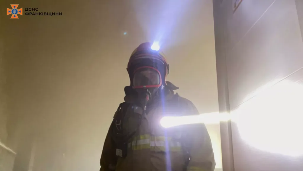 Пожежник у диму з ліхтарем на шоломі