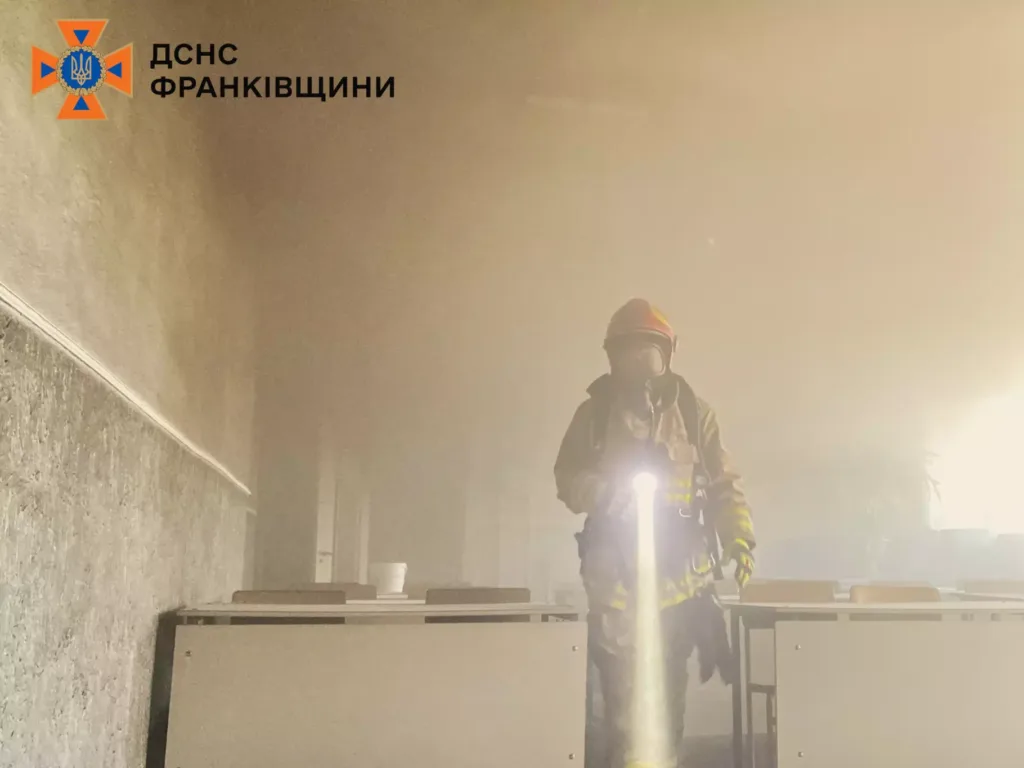 Пожежник у задимленому приміщенні з ліхтарем