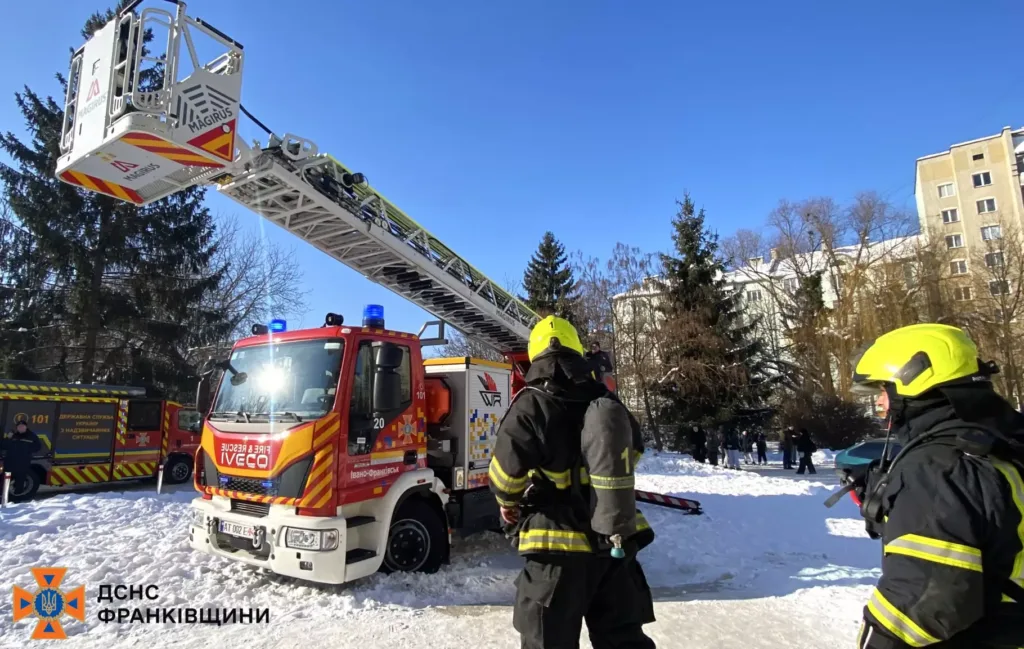 Пожежники працюють біля пожежної машини взимку
