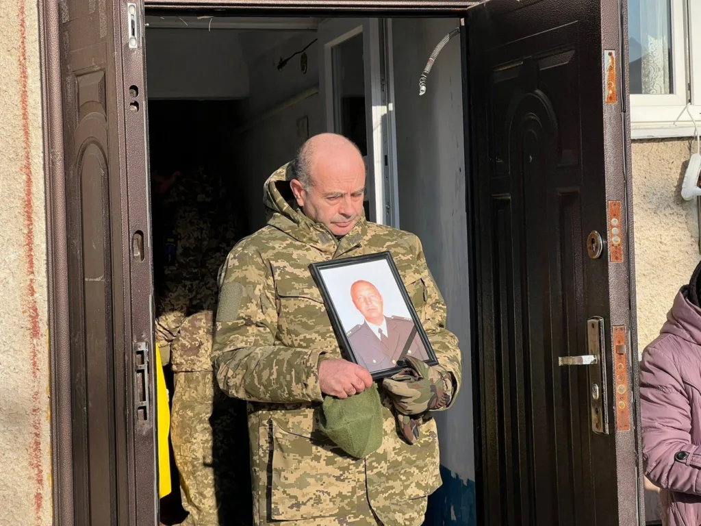 Військовий тримає портрет загиблого солдата