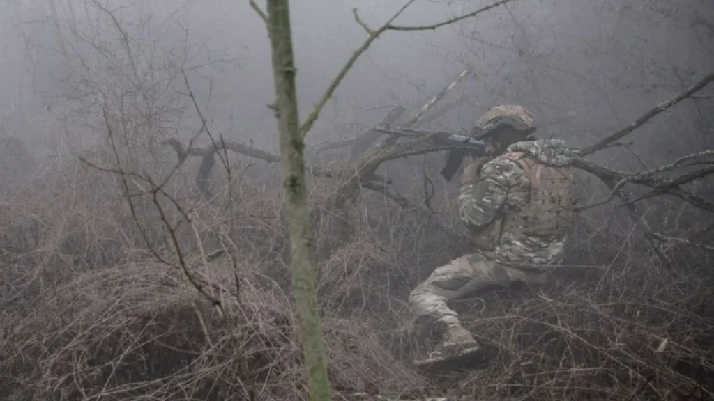 Військовий у камуфляжі в туманному лісі