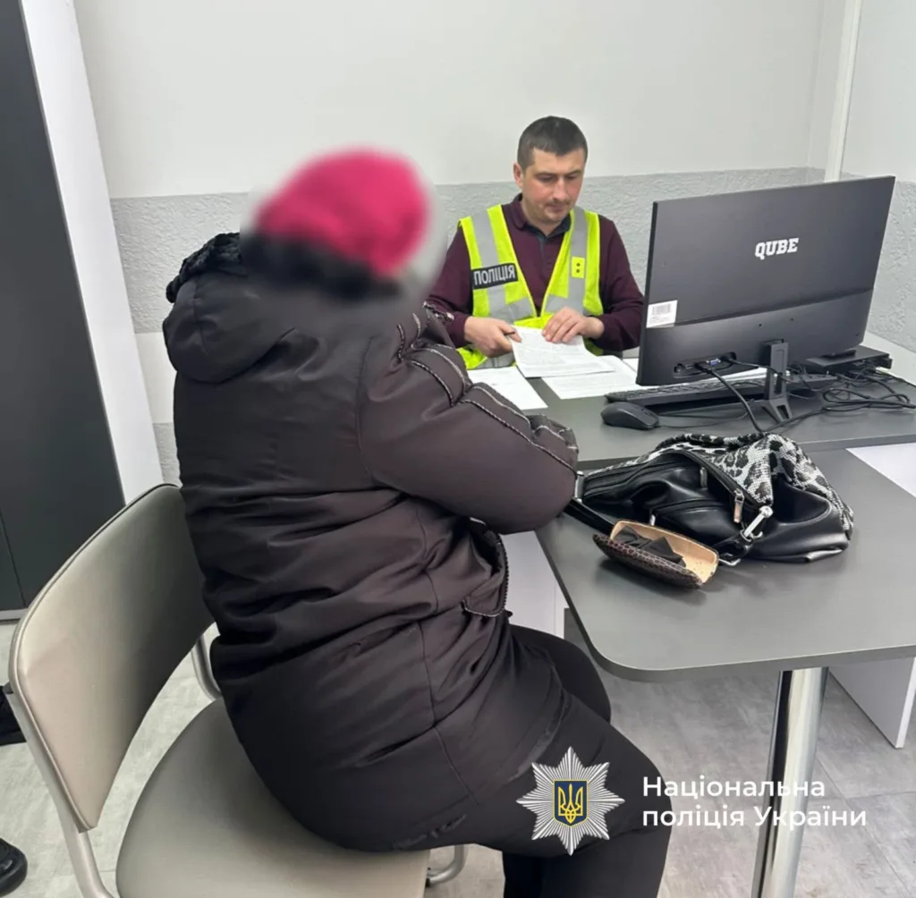 Жінка розмовляє з поліцейським у відділку поліції