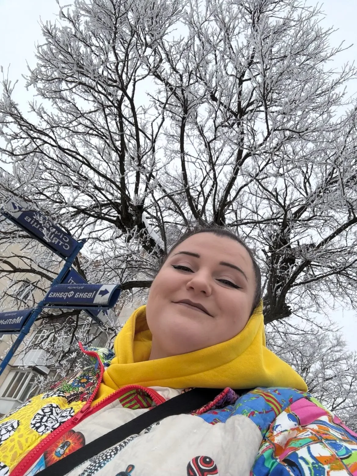 Жінка на вулиці взимку під сніжним деревом