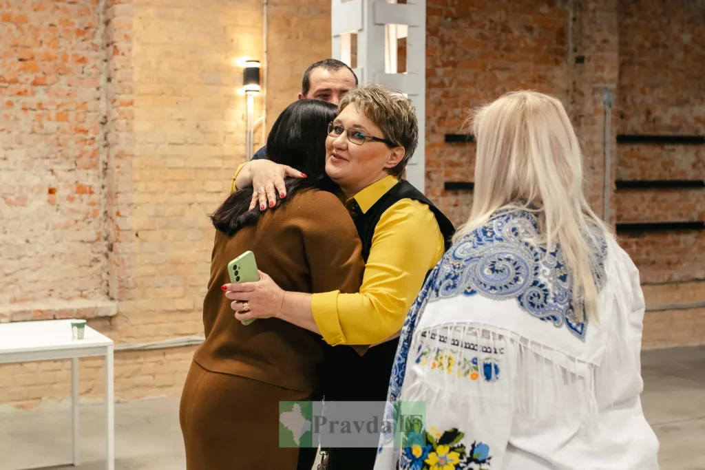 Жінки обіймаються під час зустрічі в залі