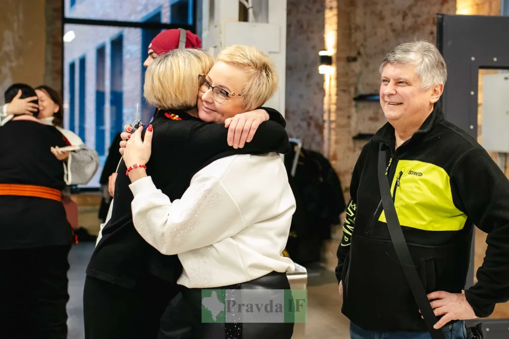 Люди обіймаються на зустрічі в приміщенні