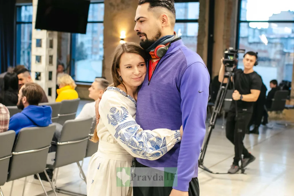 Люди обіймаються під час заходу в приміщенні