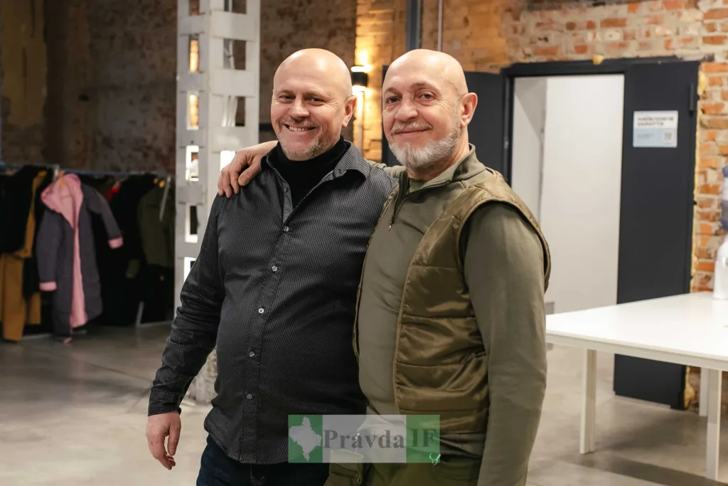 Двоє чоловіків посміхаються у сучасному приміщенні