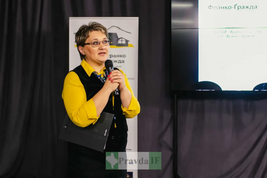 Жінка виступає з мікрофоном на презентації.