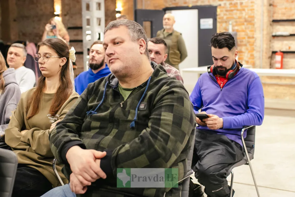 Люди слухають презентацію в сучасному приміщенні