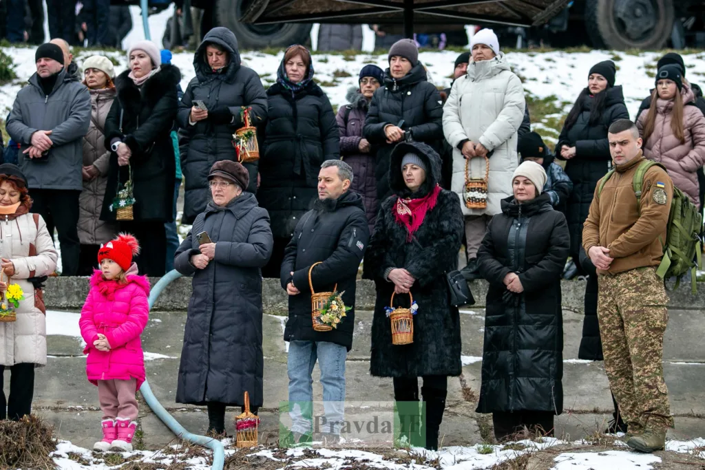 Люди стоять на вулиці з кошиками взимку